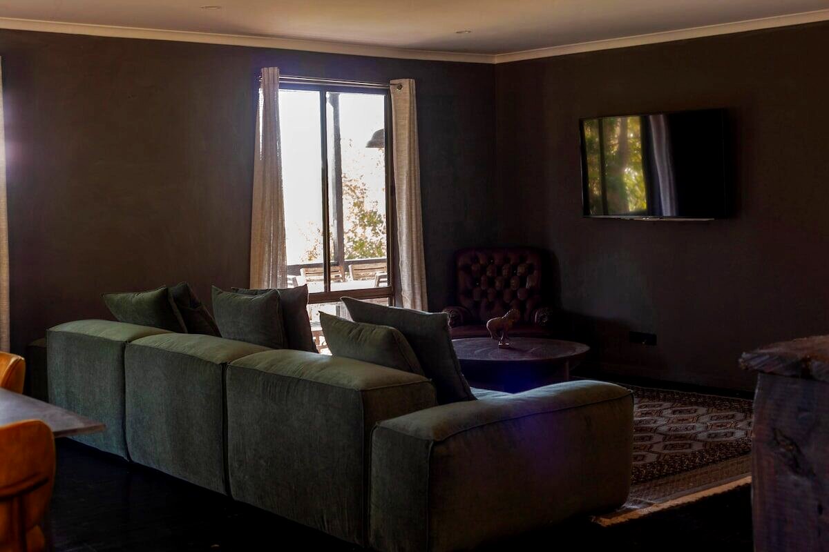 Living room with green velvet sofa and worn leather chair